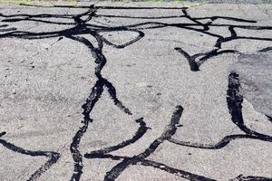 Detailed view on asphalt surfaces of different streets and roads with cracks photo