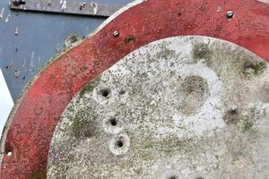 Detailed close up of bullet holes from gun shots in a traffic sign photo