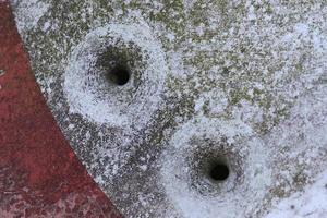 Detailed close up of bullet holes from gun shots in a traffic sign photo