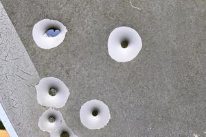 Detailed close up of bullet holes from gun shots in a traffic sign photo