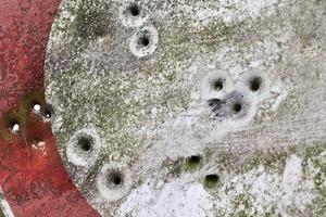 Detailed close up of bullet holes from gun shots in a traffic sign photo