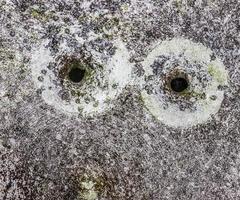 Detailed close up of bullet holes from gun shots in a traffic sign photo