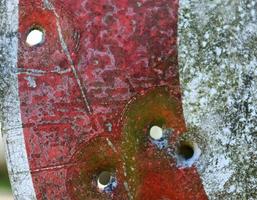 Detailed close up of bullet holes from gun shots in a traffic sign photo