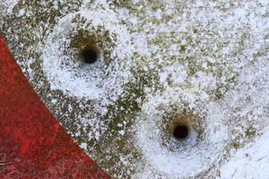 Detailed close up of bullet holes from gun shots in a traffic sign photo