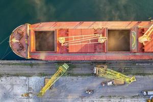 Top view from drone of a large ship loading grain for export. Water transport photo