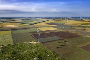 Aerial view at fields and wind turbine farms. Horizontal view photo