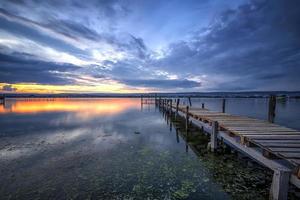 increíble puesta de sol de larga exposición en el embarcadero de madera foto