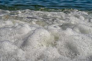 Front view of sea waves splash with foam. Close up photo