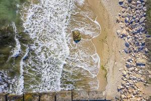 vista aérea desde el dron hasta la costa con olas de belleza y playa pedregosa. fondo del mar foto