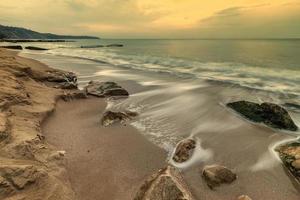 belleza nublada, paisaje marino de larga exposición con olas que fluyen entre rocas. foto