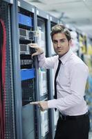 young it engineer in datacenter server room photo