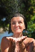 young pretty woman relaxing under shower photo