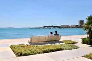 Happy young couple sitting on the beach photo