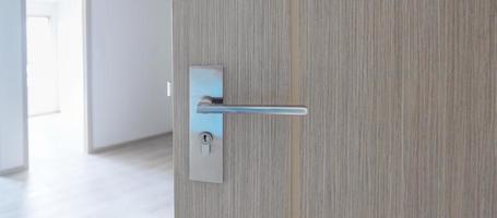 Closeup doorknob of wooden door between open or close the door photo
