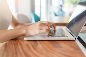 mujer usando laptop, mujer independiente escribiendo teclado computadora portátil en café u oficina moderna. tecnología, concepto digital en línea y de red foto