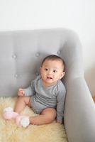 Taking photo of parents practicing babysitting by putting child in corner on soft futon.