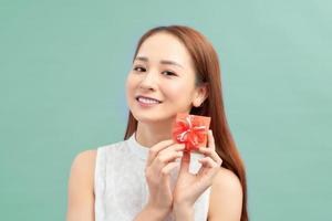 Happy smiling woman holding small red gift box photo