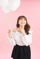 Portrait of smiling happy lady with air balloons on pink background. People concept photo