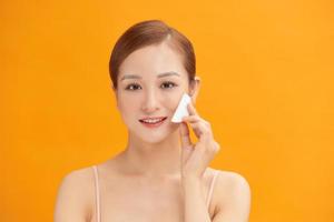 woman with a sponge wihte background cotton pad problem skin photo