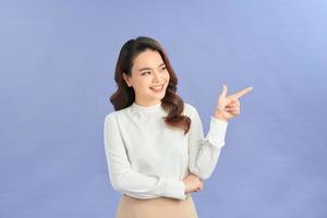 Young elegant woman pointing at purple background photo