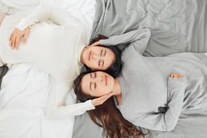 sobrecarga de cerca de la joven pareja de lesbianas acostadas en la cama juntos. foto