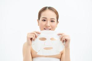 Happy young Asian girl holding face mask isolated on white background. photo