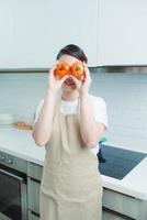 Housewife attractive lady arms holding two big tomato hiding eyes playful mood enjoy morning cooking photo