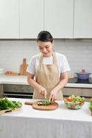 Young Woman Cooking in the kitchen. Healthy Food. Dieting Concept. photo