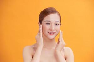 Beautiful young woman with silky skin using cotton pads on light background photo