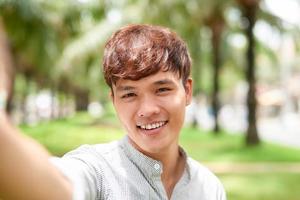 Portrait of a handsome young man taking a selfie with vintage camera photo