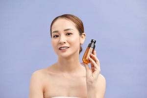 smiling young woman showing skincare products photo