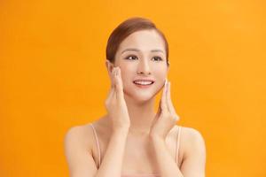 Woman using cotton pad. Happy smiling beautiful young woman cleaning skin by cotton pad. photo