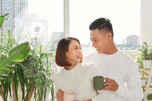 romantic happy young couple enjoying morning coffee by the window on bright day at home photo