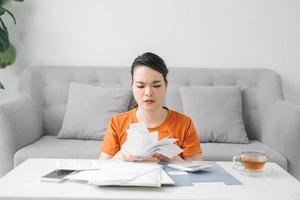 Young asian woman at home is engaged in home accounting photo