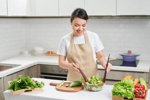 joven cocinero preparando una ensalada en una cocina acogedora foto