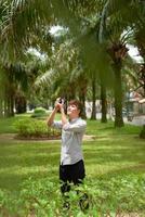 fotógrafo disparando al aire libre, está usando una cámara digital foto