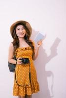 Portrait of a happy smiling young girl holding passport and travelling tickets isolated over pastel background photo