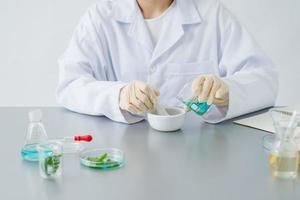 doctor woman scientist making herbal medicine in lab with herb leaves vitamin supplements mineral alternative treatment research. photo