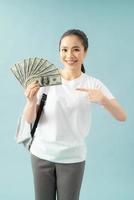 Amazed girl student pointing index finger on herself hold fan of dollar banknotes photo