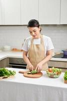 cook Woman cuts vegetables in the kitchen photo