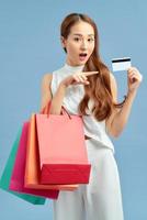 Shopping Woman concept, portrait or isolated an beautiful Asian woman wearing dress, holding shopping bags and credit cards. photo