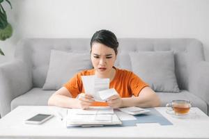 Sad woman looking at monthly bills photo