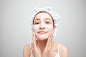 Asian woman in a white towel on her head with a mask on her face photo