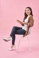 Beautiful girl with book relaxing on chair photo