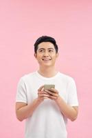 Happy male using smartphone isolated on pink background with clipping path photo