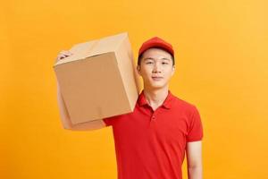 handsome young delivery man portrait isolated on yellow photo