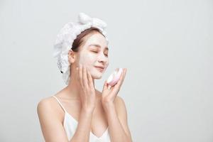 Spa Asian woman applying facial clay mask. Spa beauty concept. photo