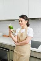 Healthy Lifestyle Concept. Close up portrait of smiling girl drinking morning smoothie made of super foods photo