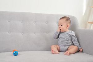 pretty baby sitting and smiling on the sofa photo