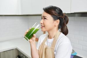 Healthy Lifestyle Concept. Close up portrait of smiling girl drinking morning smoothie made of super foods photo